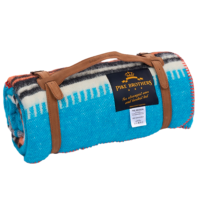 Rolled-up blanket with brown leather strap and Pike Brothers label