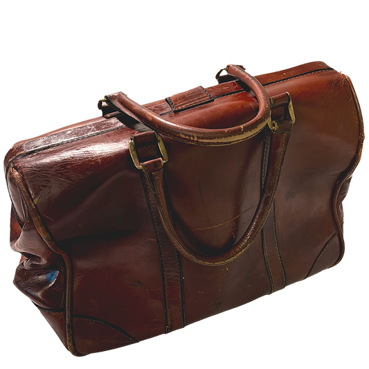 A vintage brown leather duffel bag with distressed edges and gold-tone hardware.