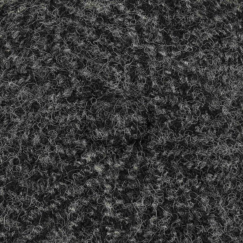 Close-up texture of a black shag rug with curly, looped fibers filling the frame.