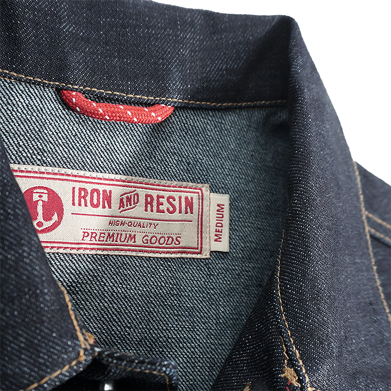 Close-up of a denim jacket with an 'Iron and Resin' label