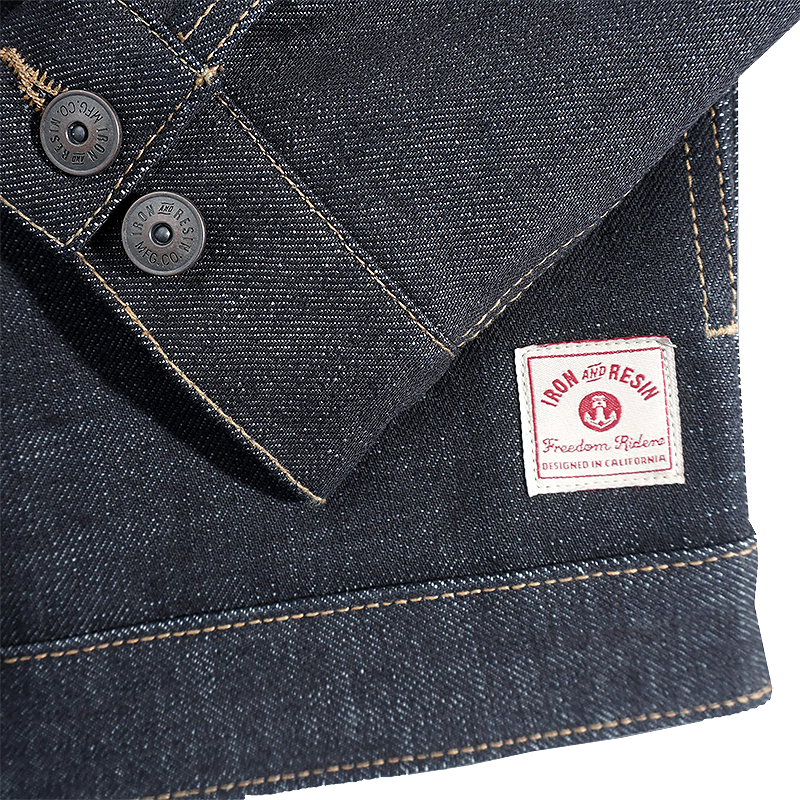 Close-up of a denim jacket with the Iron & Resin brand label