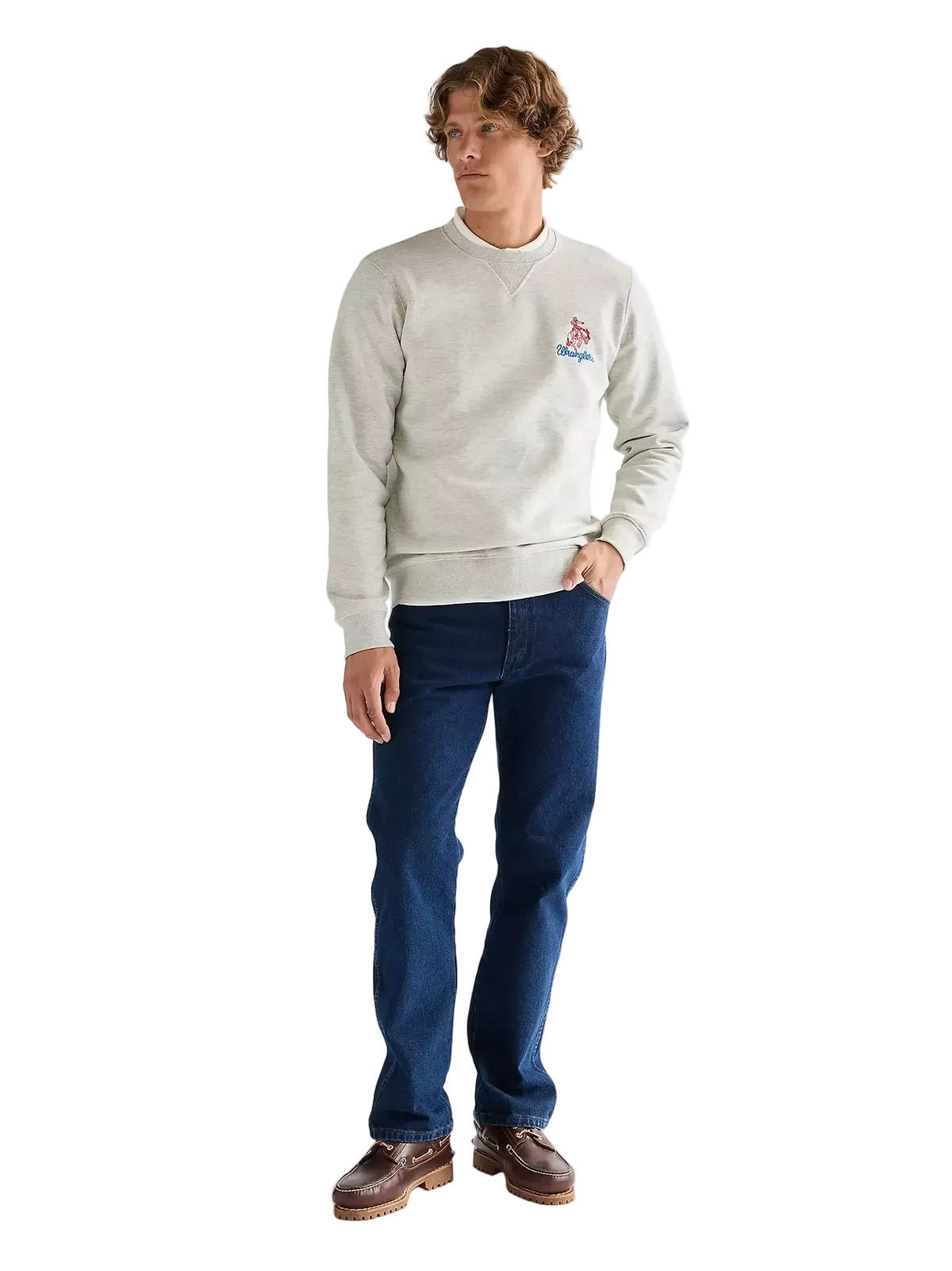 Man wearing a light gray sweatshirt with a logo and blue jeans