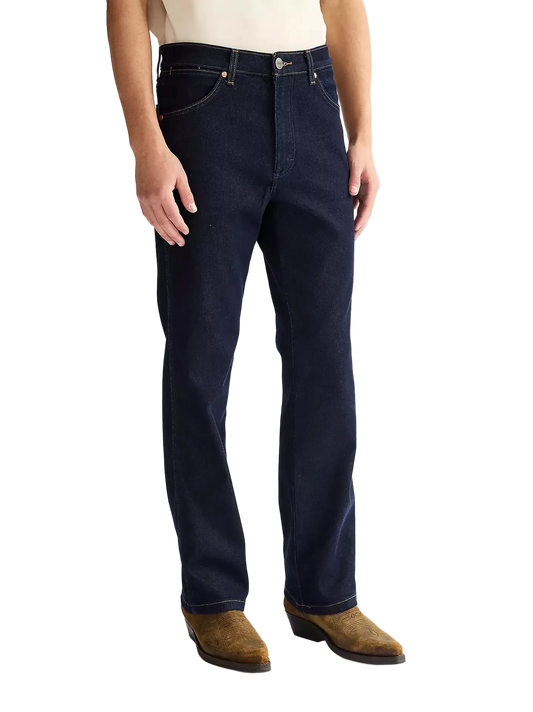 Person wearing dark blue Wrangler jeans and brown boots