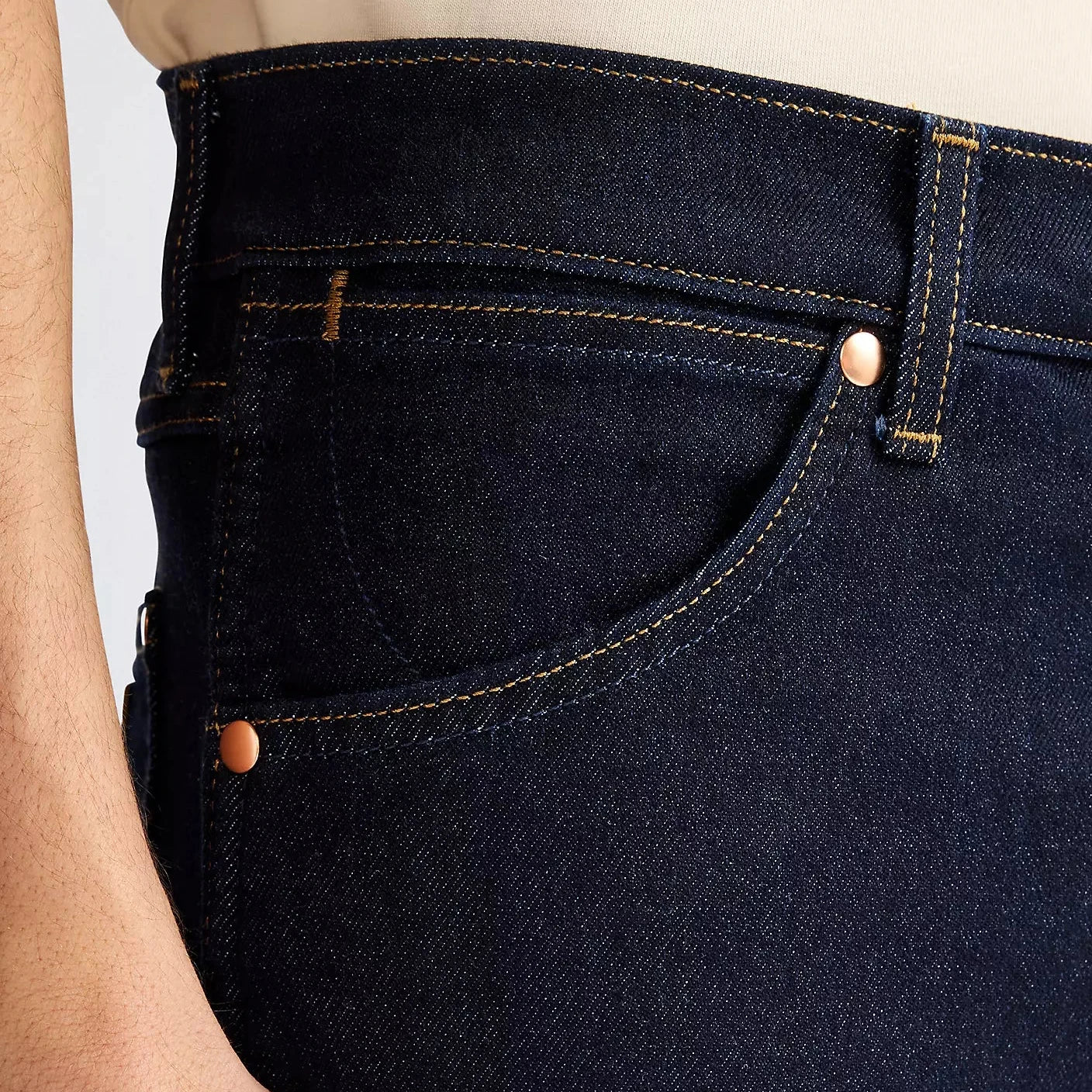 Dark blue jeans with a close-up of the waistband and pocket area.
