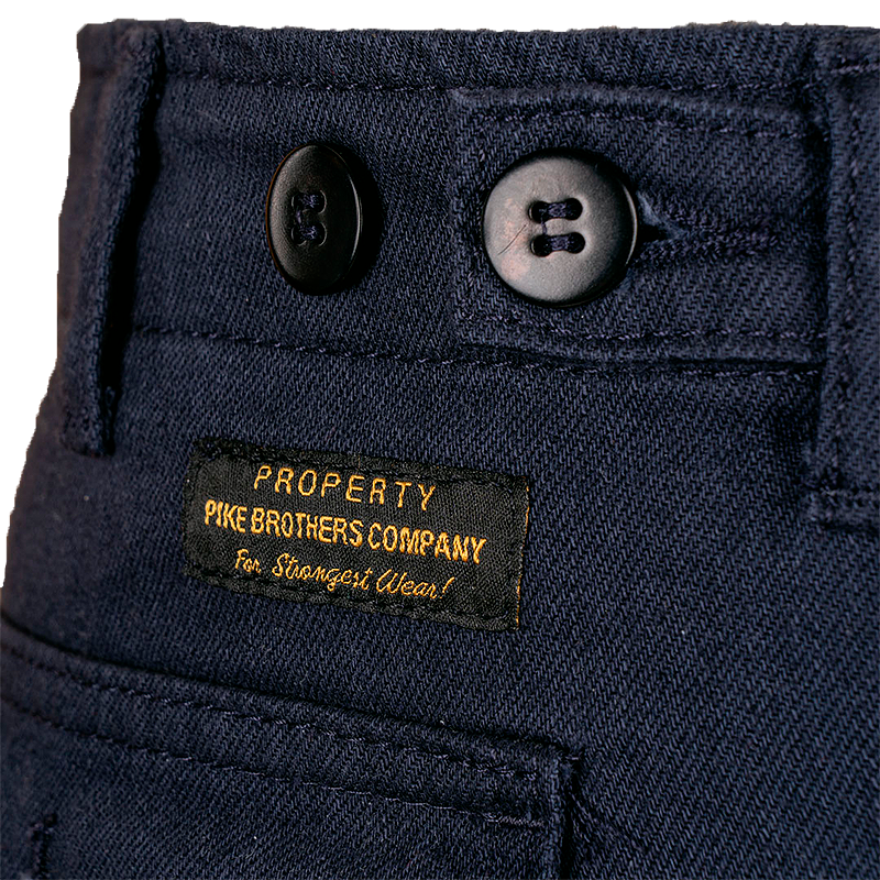 Close-up of navy blue pants with buttons and a label