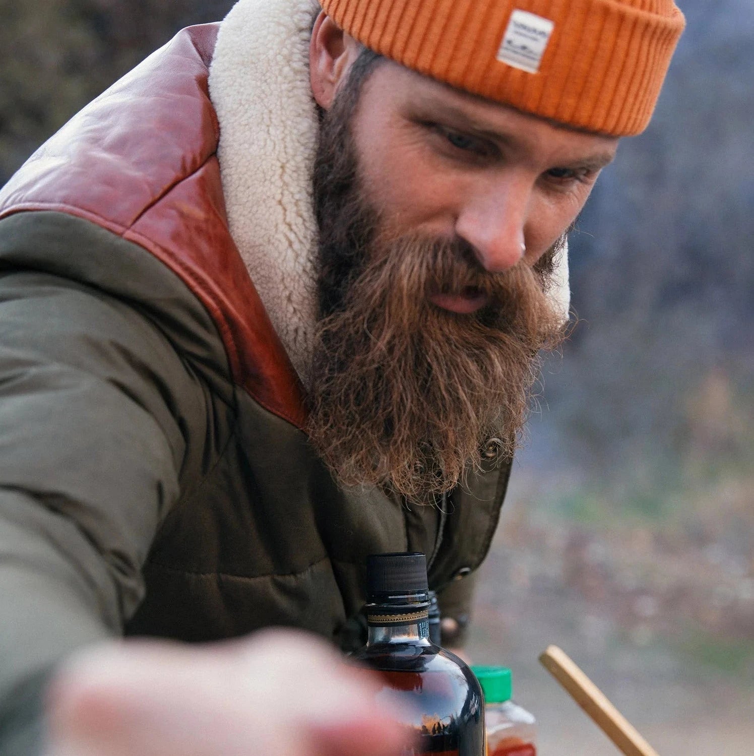 A man with beard wearing Iron & Resin’s Basin Jacket in olive. 