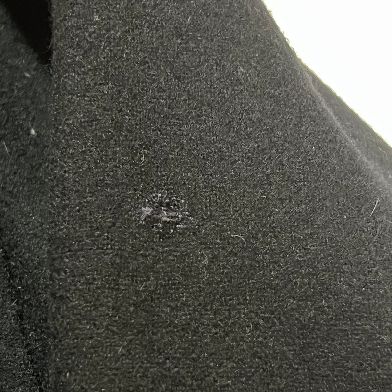 Close-up of a dark textured surface with a small dark spot.