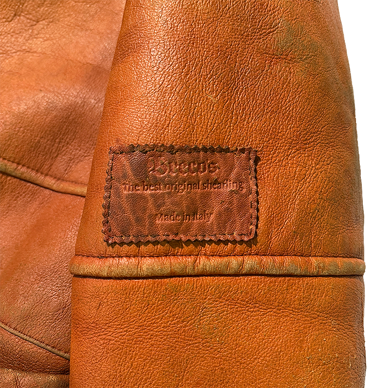 Close-up of a brown leather jacket with a Breco's label.
