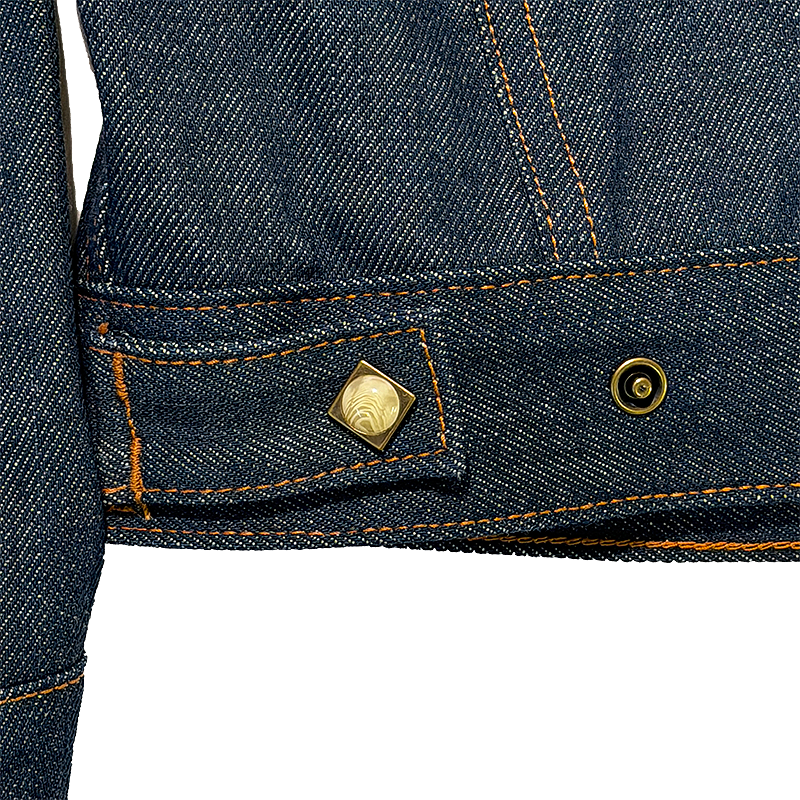 Close-up of a denim jacket with a pearl snap button
