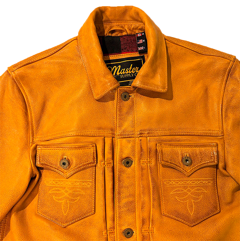 Close-up of a bright orange leather jacket with two front flap pockets, decorative stitching, and a visible Master Supply Co. neck label.