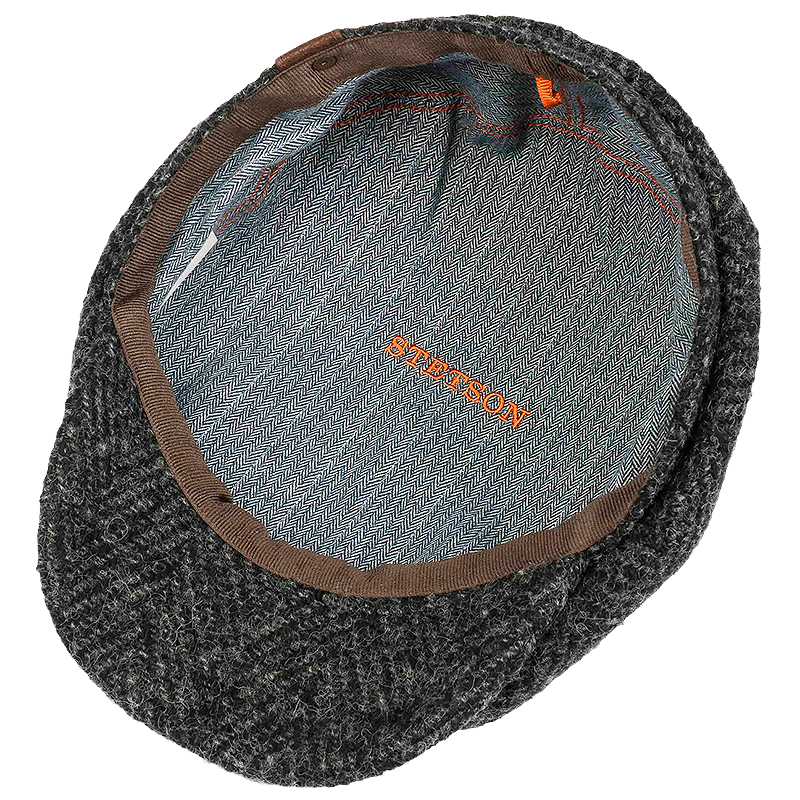 Stetson Hatteras Herringbone Flat Cap in black, showing the interior lining with a blue-gray fabric base, brown trim, and orange 'STETSON' embroidery.