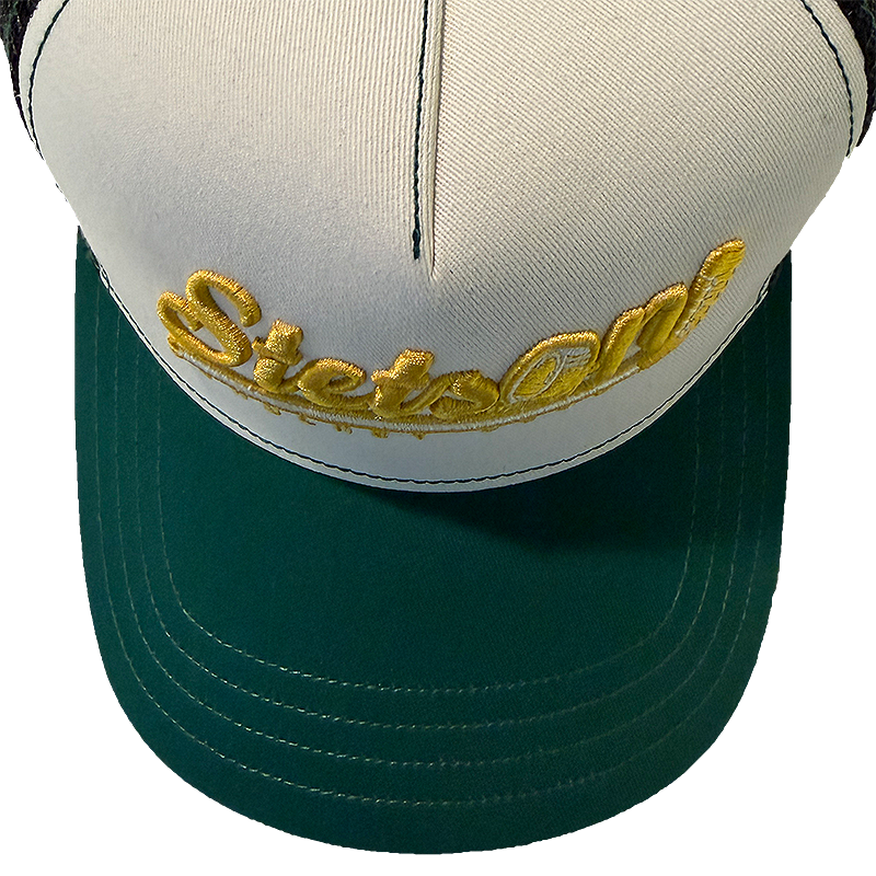 Stetson Hockey Club Trucker Cap seen from above with the cream white panel, yellow embroidery and dark green visor with contrast stitching.