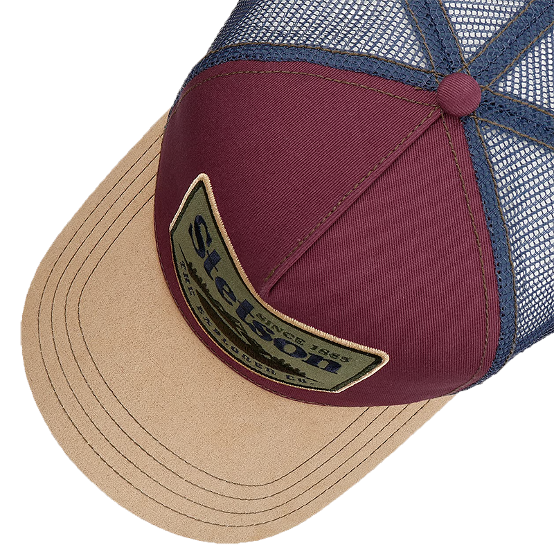 Close-up of a Stetson The Explorer Co. Trucker Cap showing the front panel, mesh back, and brim. The front panel is burgundy with a Stetson patch, and the brim and mesh are in beige and blue-gray respectively.